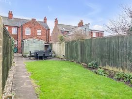A garden with a shed and outdoor furniture at Bay Tree Cottage in Heacham