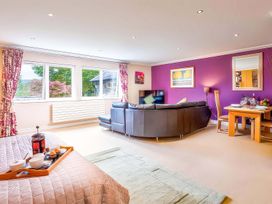A living room with a sofa and dining area at The Gallery in Windermere