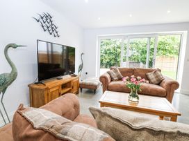A living room with a sofa and TV at The Ivy in Norwich