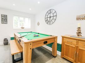 A game room with a pool table and wall clock at The Ivy in Norwich