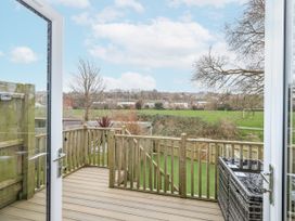 A deck area with railings and a view of grass at 8 Park View Grove in Weymouth