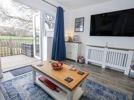 A living room with a coffee table and a television at 8 Park View Grove in Weymouth