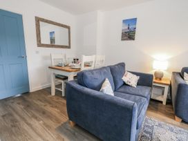 A living room with a sofa and dining area at 8 Park View Grove Weymouth