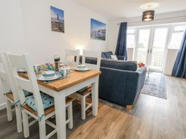 A dining area with a table set and a sofa at 8 Park View Grove Weymouth