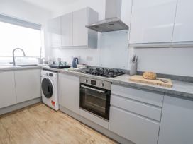 A kitchen with sink, washing machine, oven, and gas stove at 8 Park View Grove in Weymouth