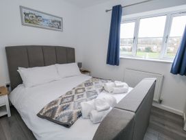 A bedroom with a bed and bedside table at 8 Park View Grove in Weymouth