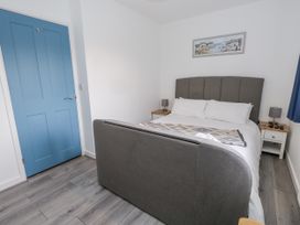 A bedroom with a bed and bedside tables at 8 Park View Grove in Weymouth