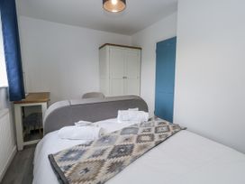 A bedroom with a bed, blanket, and wardrobe at 8 Park View Grove in Weymouth