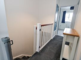 A hallway with a staircase and console table at 8 Park View Grove in Weymouth