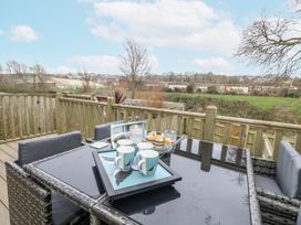 An outdoor dining area with a table set for tea at 8 Park View Grove Weymouth