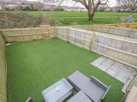 A garden with grass flooring and seating at 8 Park View Grove in Weymouth
