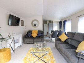 A living room with sofas and a television at 33 Woodpecker Lodge Llanarth