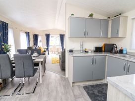 A kitchen with a dining area in 33 Woodpecker Lodge Llanarth