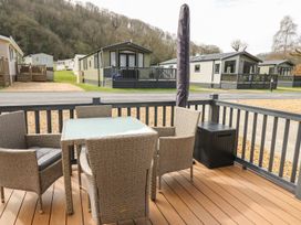 An outdoor seating area with a table and chairs at 33 Woodpecker Lodge Llanarth
