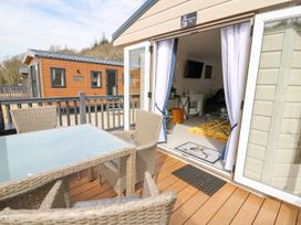 An outdoor seating area with a table and chairs at 33 Woodpecker Lodge Llanarth
