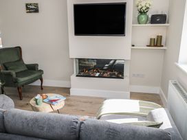 A living room with a fireplace and television at Doire Fhatharta Beag, Carraroe, County Galway