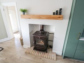 A living room with a wood stove and fireplace at Doire Fhatharta Beag, Carraroe, County Galway