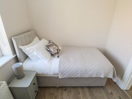 A bedroom with a bed and nightstand at Doire Fhatharta Beag in Carraroe, County Galway