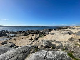 A beach area with rocks and sand at Red House, Carraroe, County Galway
