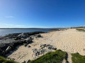 A beach with sand and rocks at Red House in Carraroe, County Galway