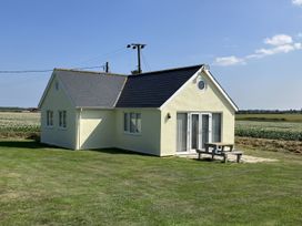 A house with a slate roof and a bench outside at Seadrift near Happisburgh