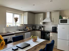 A kitchen with appliances and a table at Seadrift near Bush Estate near Happisburgh