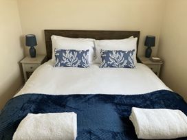 A bedroom with a bed and nightstand at Seadrift near Happisburgh