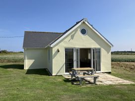 An outdoor view of a house with a table in front at Seadrift Bush Estate near Happisburgh