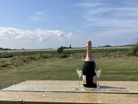 A champagne bottle and glasses on a table in an outdoor area at Seadrift near Happisburgh