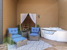 An outdoor lounge area with seating and a hot tub at Bluebelle - Crossgate Luxury Glamping Hartsop