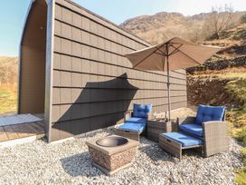 An outdoor seating area with a fire pit and armchairs at Bluebelle - Crossgate Luxury Glamping Hartsop