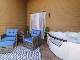A patio with chairs, a hot tub and a rug at Bluebelle - Crossgate Luxury Glamping Hartsop