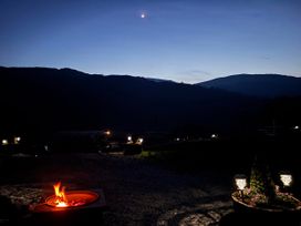 An outdoor area with a fire pit and mountains in the background at Bluebelle - Crossgate Luxury Glamping, Hartsop