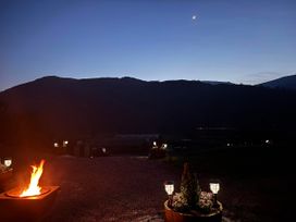 An outdoor area with a fire pit and mountains in the background at Bluebelle - Crossgate Luxury Glamping Hartsop