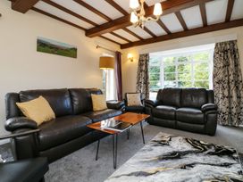 A living room with sofas and a table at Barton Lodge in Porlock