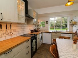 A kitchen with cabinets, a stove, and a sink at Barton Lodge in Porlock