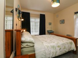 A bedroom with a bed and a washbasin at Barton Lodge in Porlock