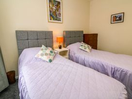 A bedroom with two single beds and a lamp at Barton Lodge in Porlock