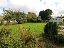 A garden with trees and a shed at Barton Lodge in Porlock