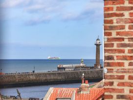 A view of a lighthouse and ship on the sea at The Four Views in Whitby