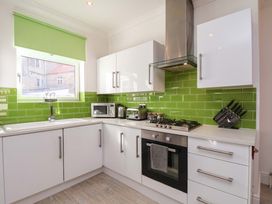 A kitchen with sink, microwave, and cooking range at The Four Views in Whitby