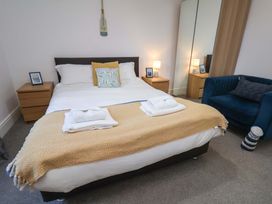 A bedroom with a bed and blue chair at The Four Views in Whitby