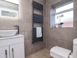 A bathroom with sink, towel rail, toilet and window at The Four Views in Whitby