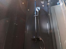 A shower setup with a glass panel at The Four Views in Whitby