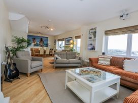 A living room with a sofa and dining area at Snowdonia View Pwllheli