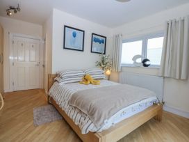 A bedroom with a bed and pictures on the wall at Snowdonia View in Pwllheli