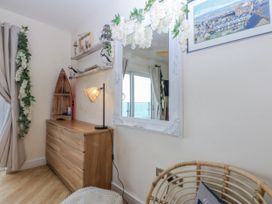 A bedroom with a dresser and a mirror at Snowdonia View in Pwllheli