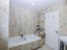 A bathroom with a bathtub and towels at Snowdonia View in Pwllheli