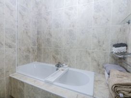 A bathroom with a bathtub and towels at Snowdonia View in Pwllheli