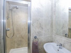 A bathroom featuring a shower, sink, and mirror at Snowdonia View in Pwllheli